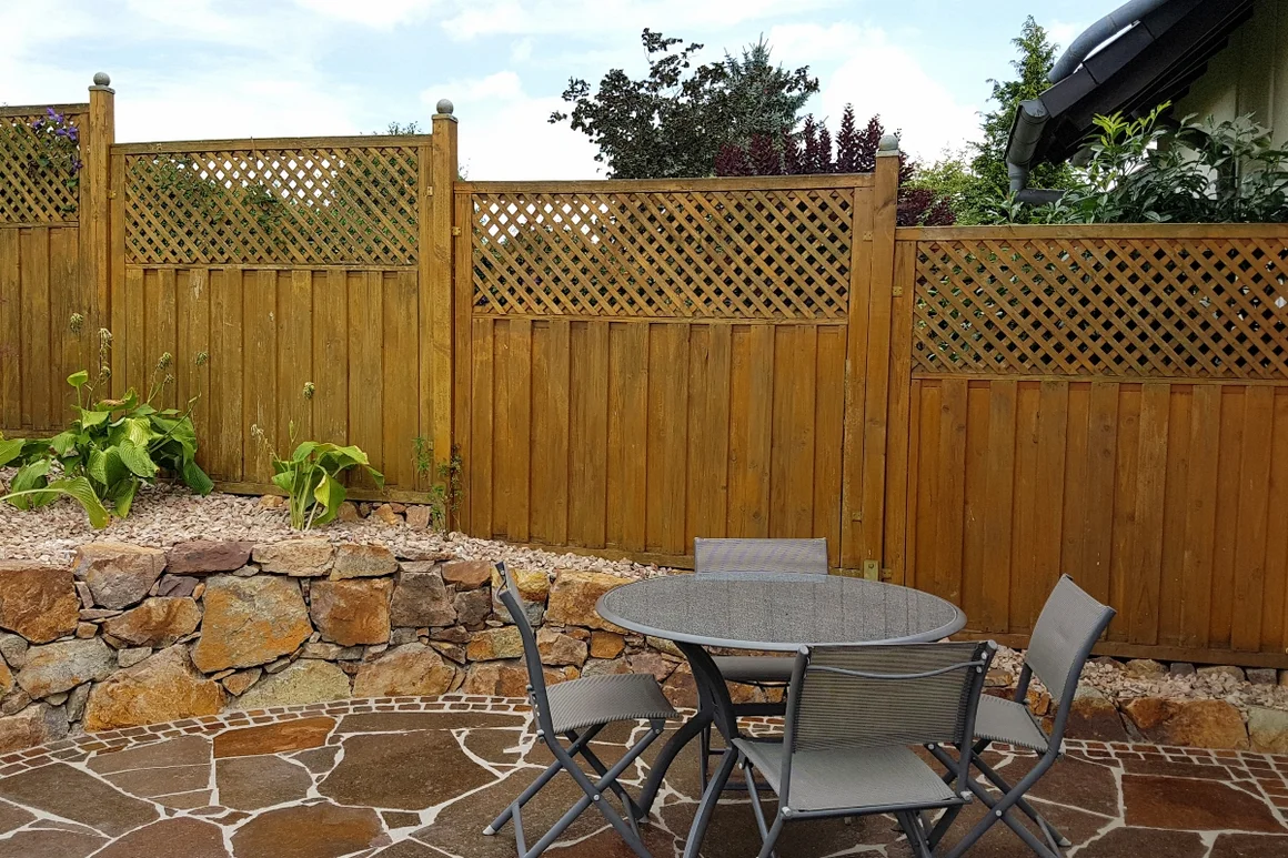 Holztisch mit Stühlen auf Terrasse